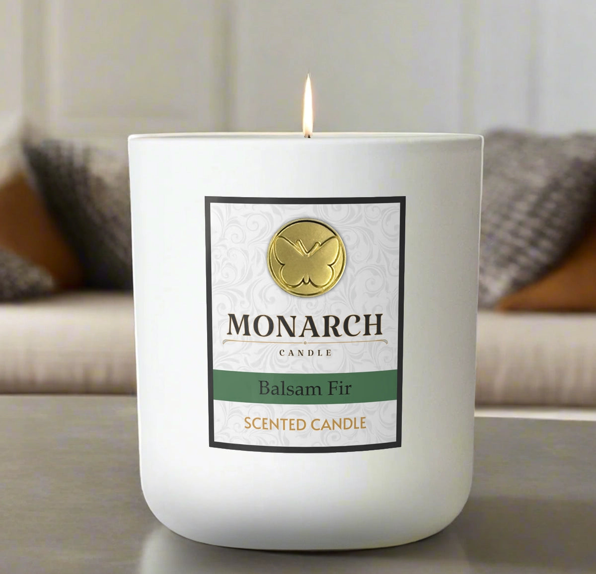 Monarch Candle labeled “Balsam Fir” glowing gently in a white luxury glass vessel against a warm indoor background.