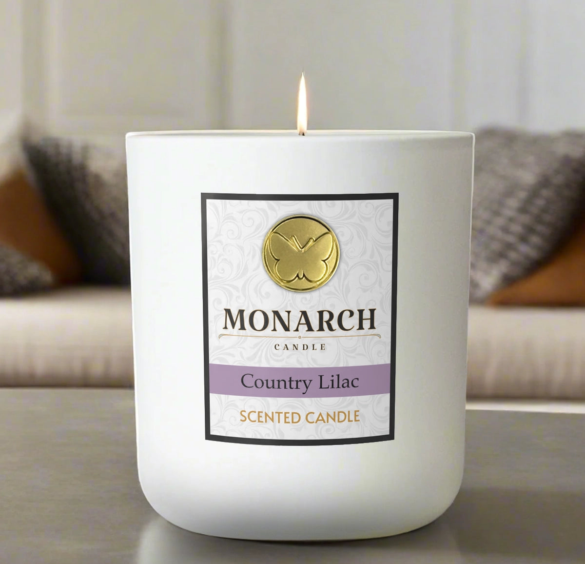 Monarch Candle labeled “Country Lilac” glowing gently in a white luxury glass vessel against a warm indoor background.
