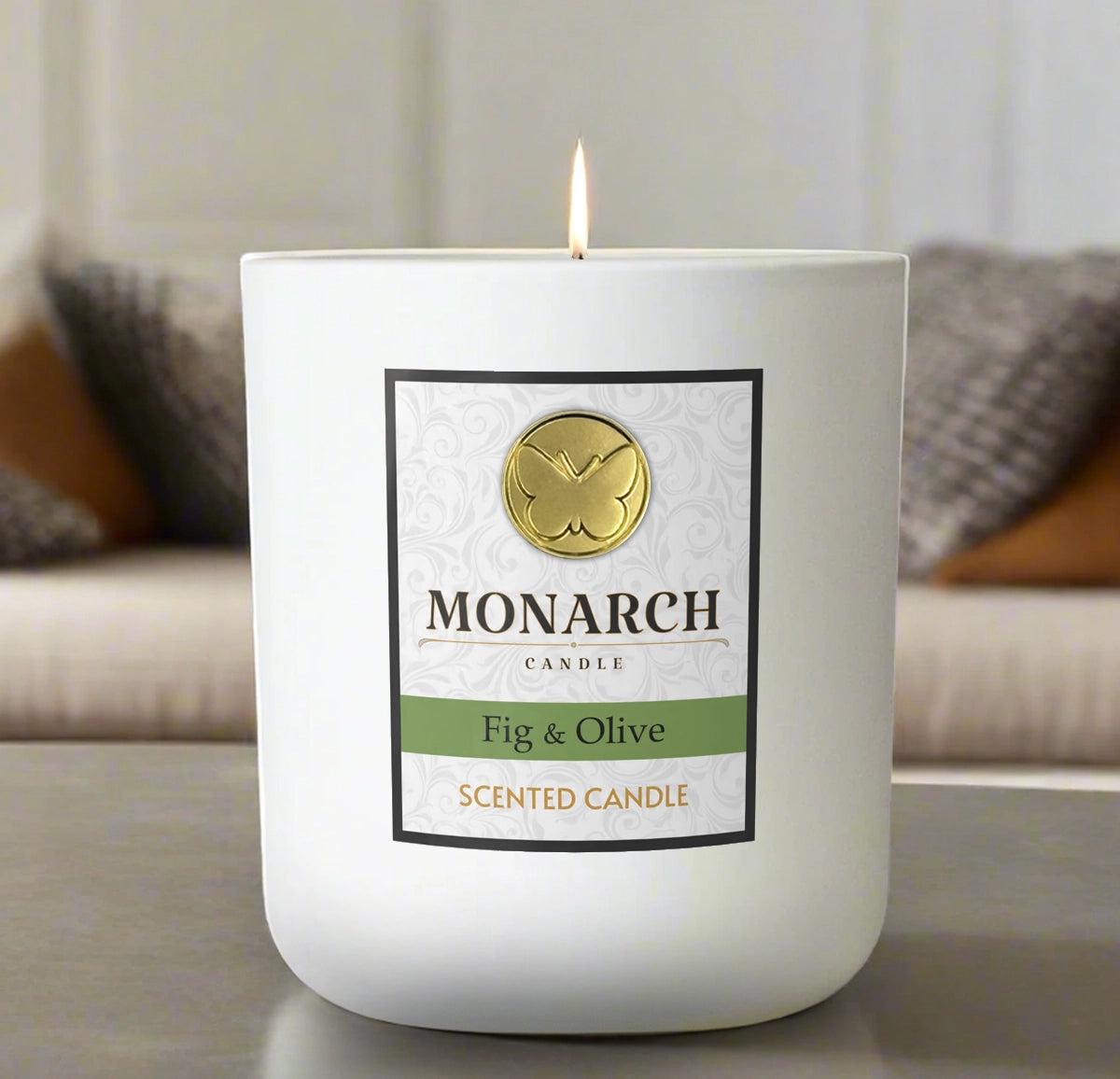 Monarch Candle labeled “Fig & Olive” glowing gently in a white luxury glass vessel against a warm indoor background.