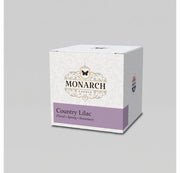 Monarch Candle votive box packaging labeled “Country Lilac” displayed on a neutral gray background.