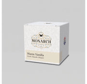 Monarch Candle votive box packaging labeled “Warm Vanilla” displayed on a neutral gray background.