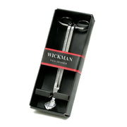 Wickman brand wick trimmer in pewter finish, displayed in its black packaging with on white background.